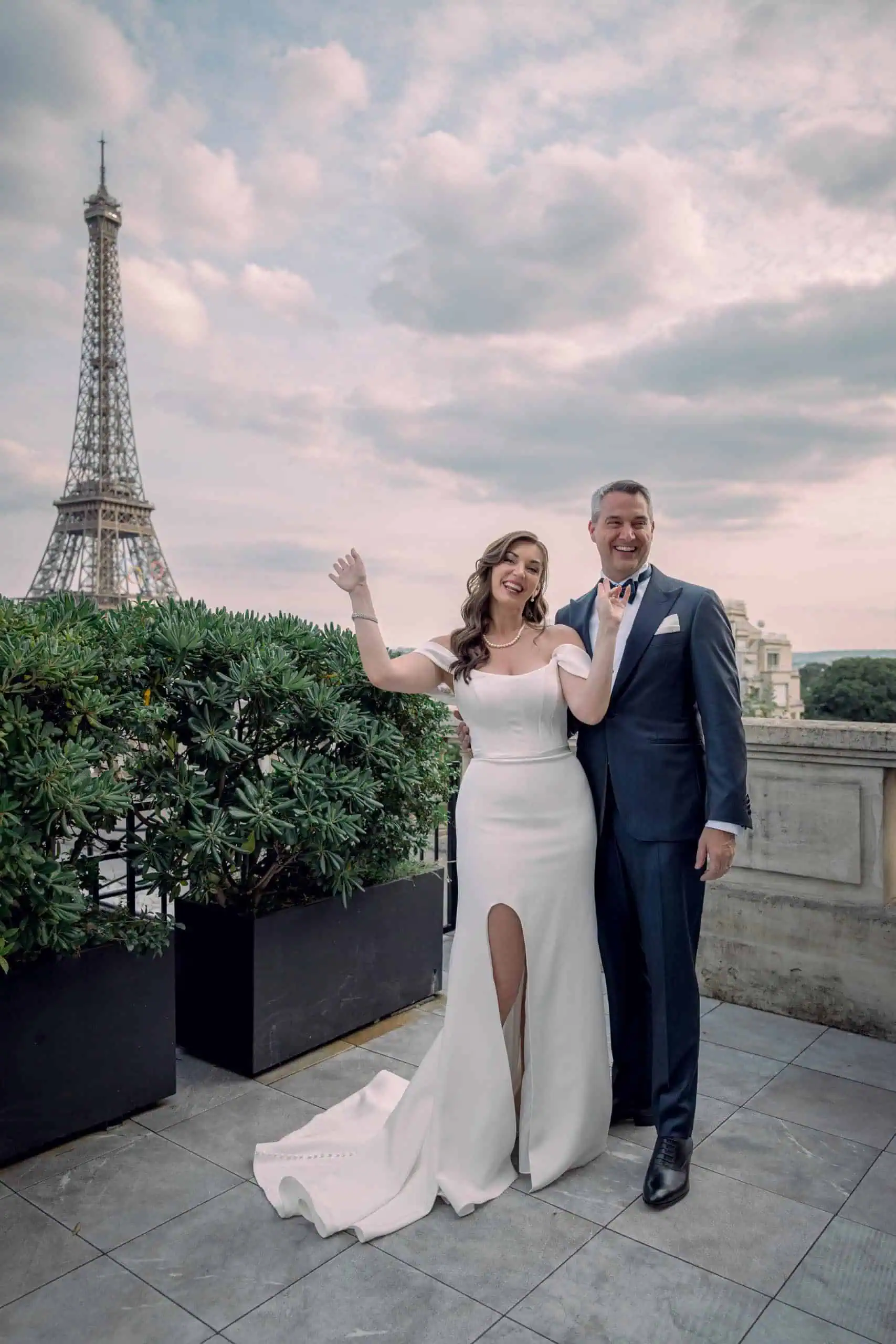 Newlywed couple celebrating waving rooftop Eiffel Tower Paris - Paris by Finzi